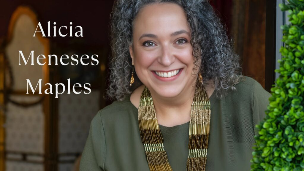 Photo of Alicia Meneses Maples wearing olive green with a multi-colored beaded brown necklace with matching earrings. She is smiling looking around a topiary. Blurred background chair, curtains, dar room. Text: Alicia Meneses Mapes to the right side. White text. 